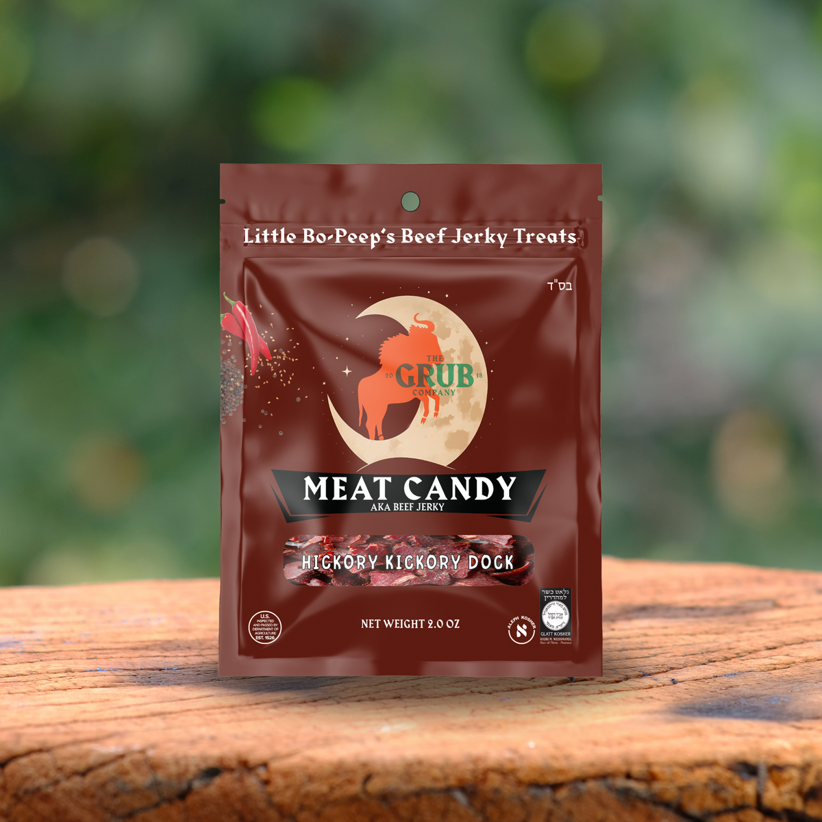 Meat Candy beef jerky pouches outdoors on a wooden log