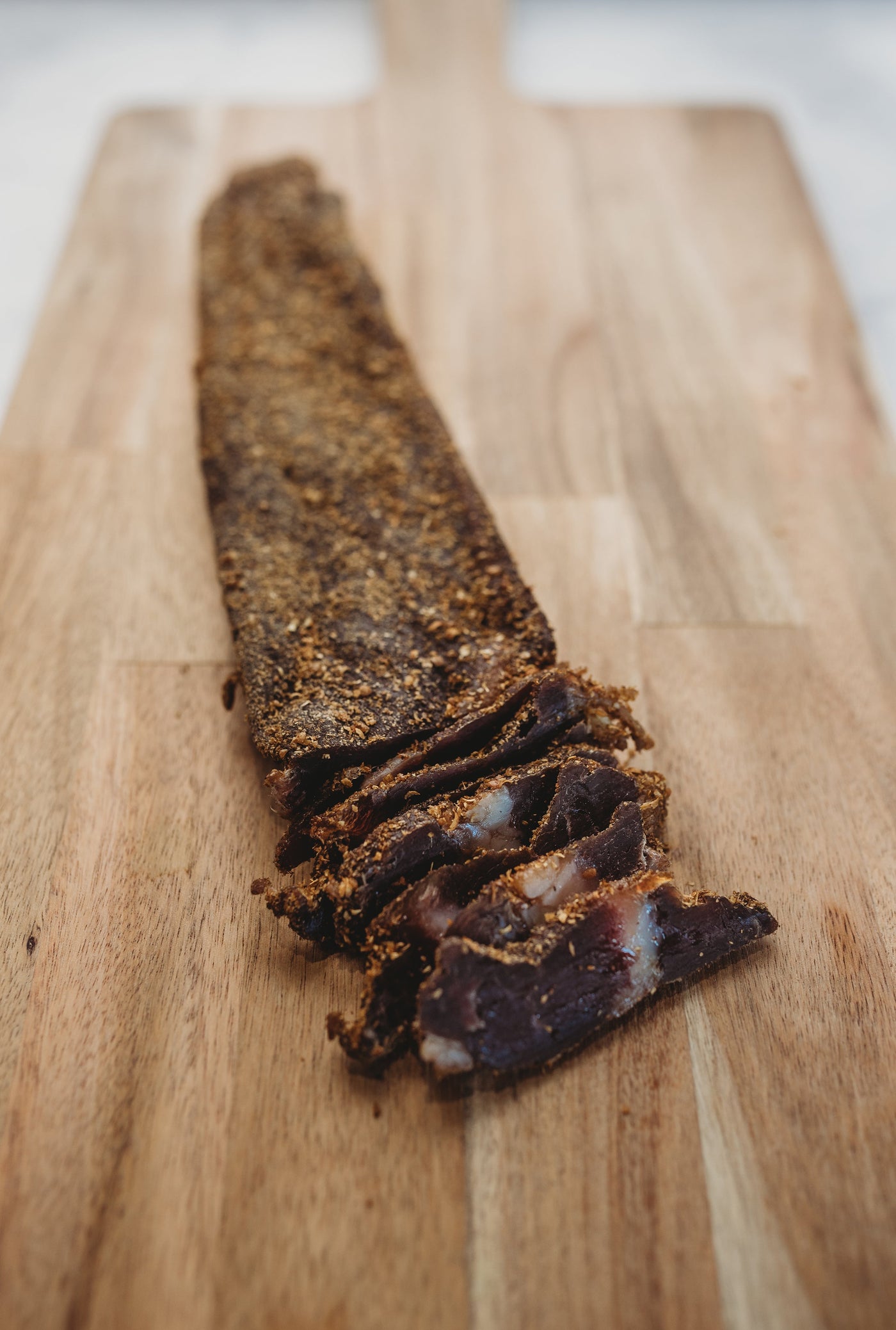 A biltong slab beside slices cut from it
