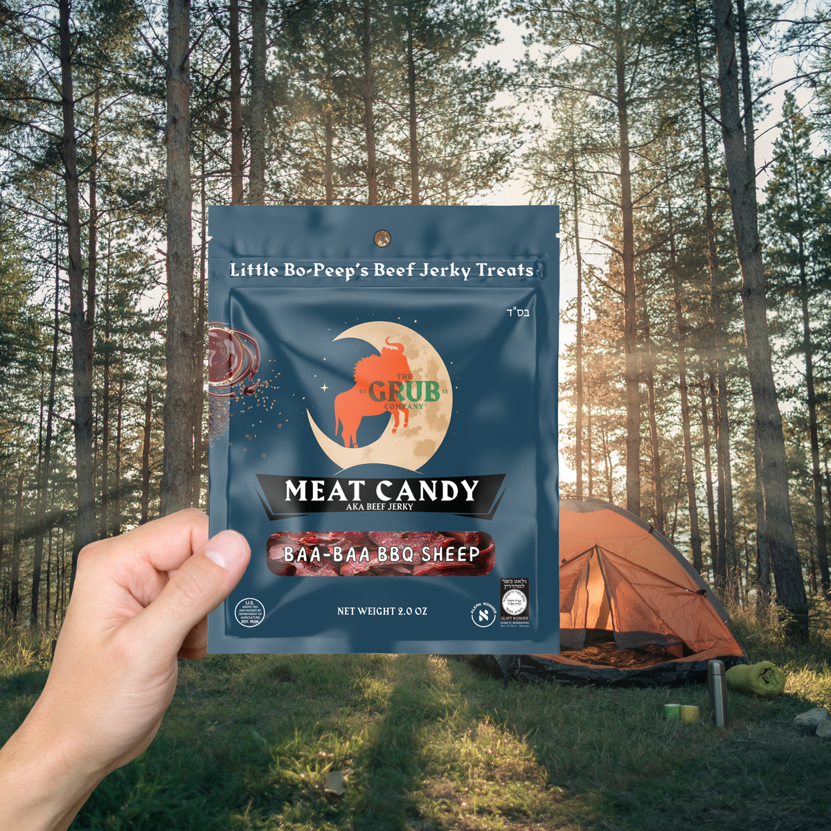 A pouch of Meat Candy held up at a woodland campsite