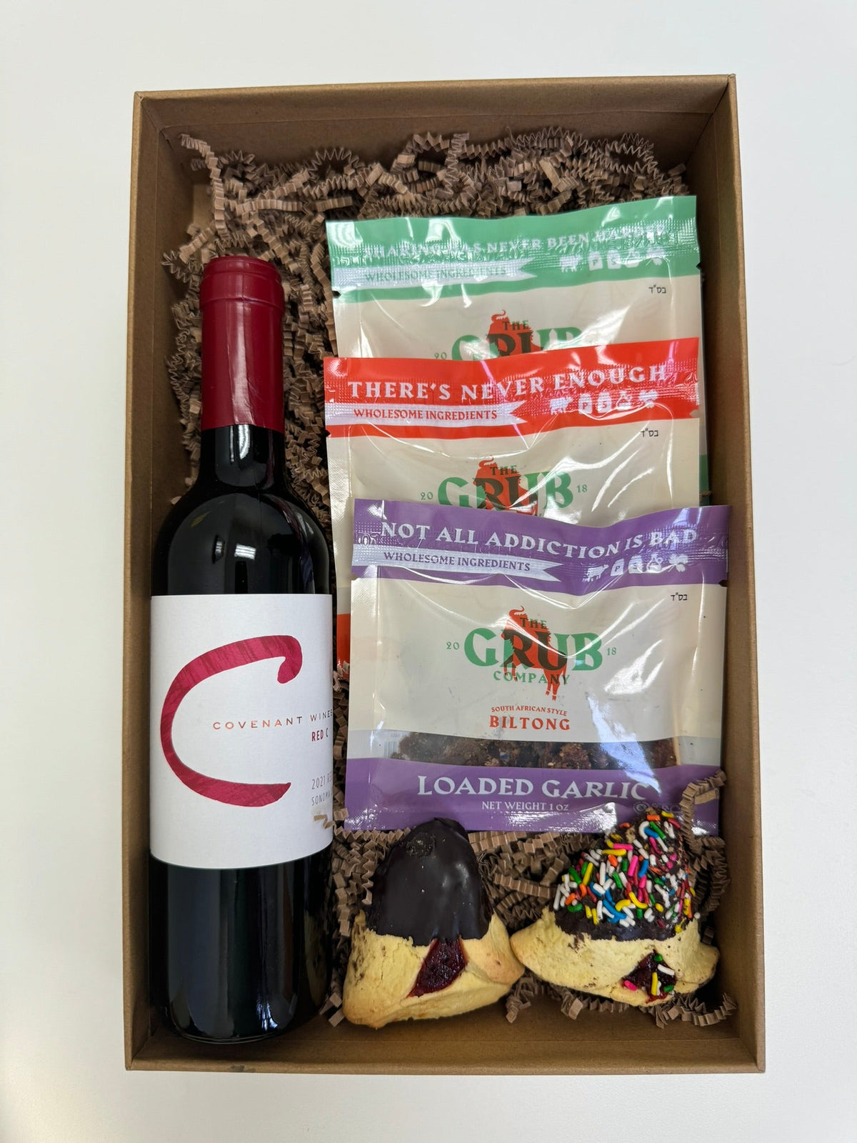 A wooden gift crate holding biltong and wine
